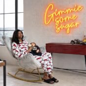 alt="A mother comfortably breastfeeding in a grey nursery chair"