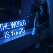 dual monitor setup in small bedroom with neon signs